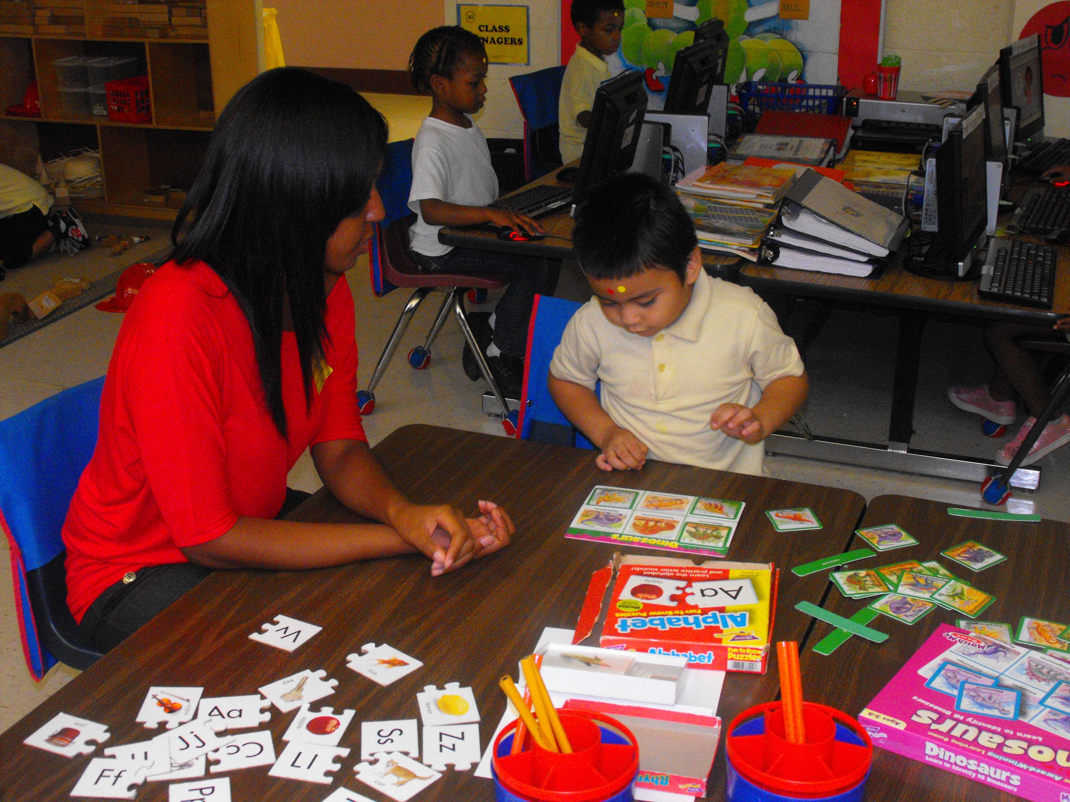 Student and volunteer playing a card game 